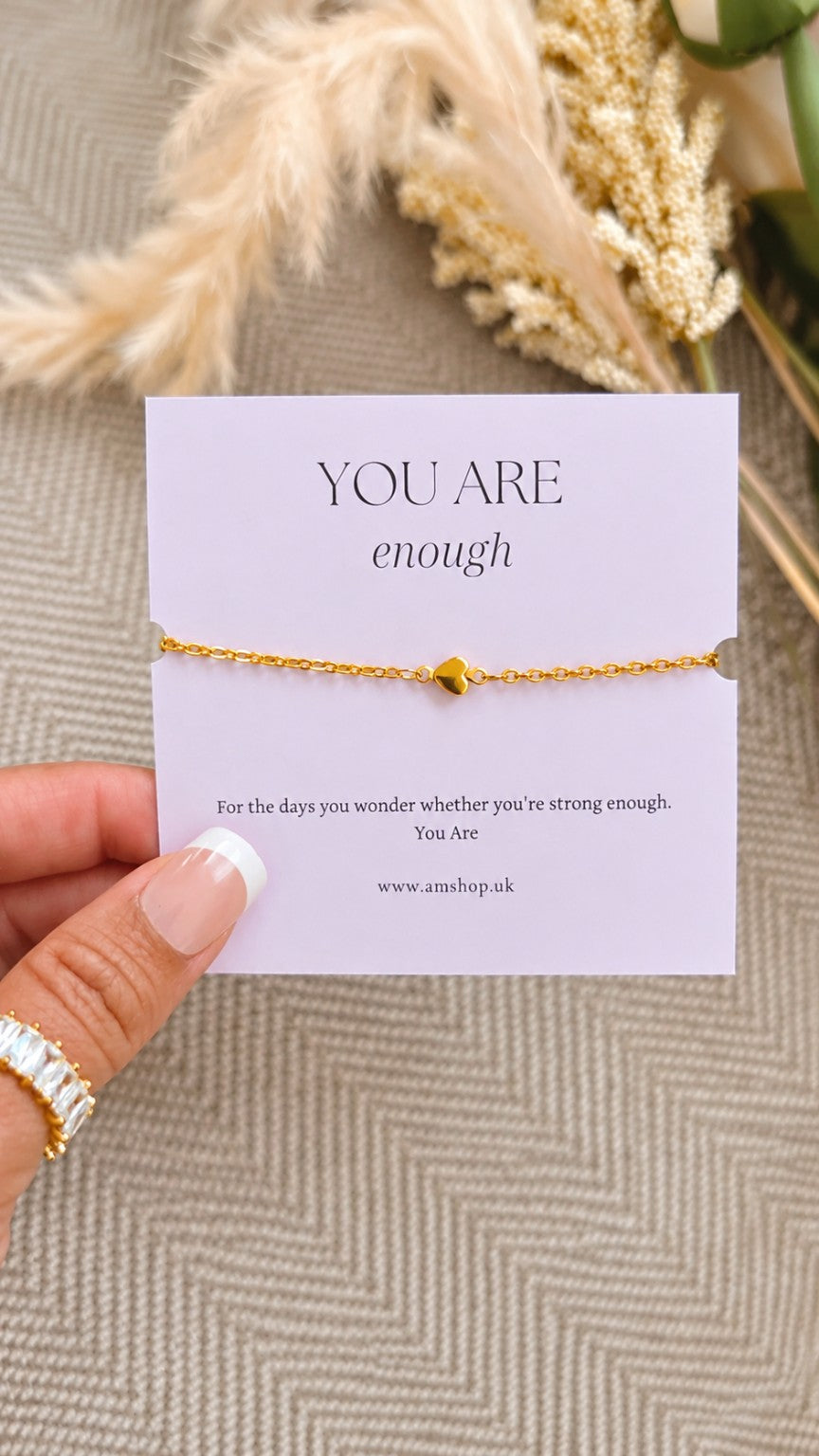Hand holding You Are Enough bracelet affirmation card