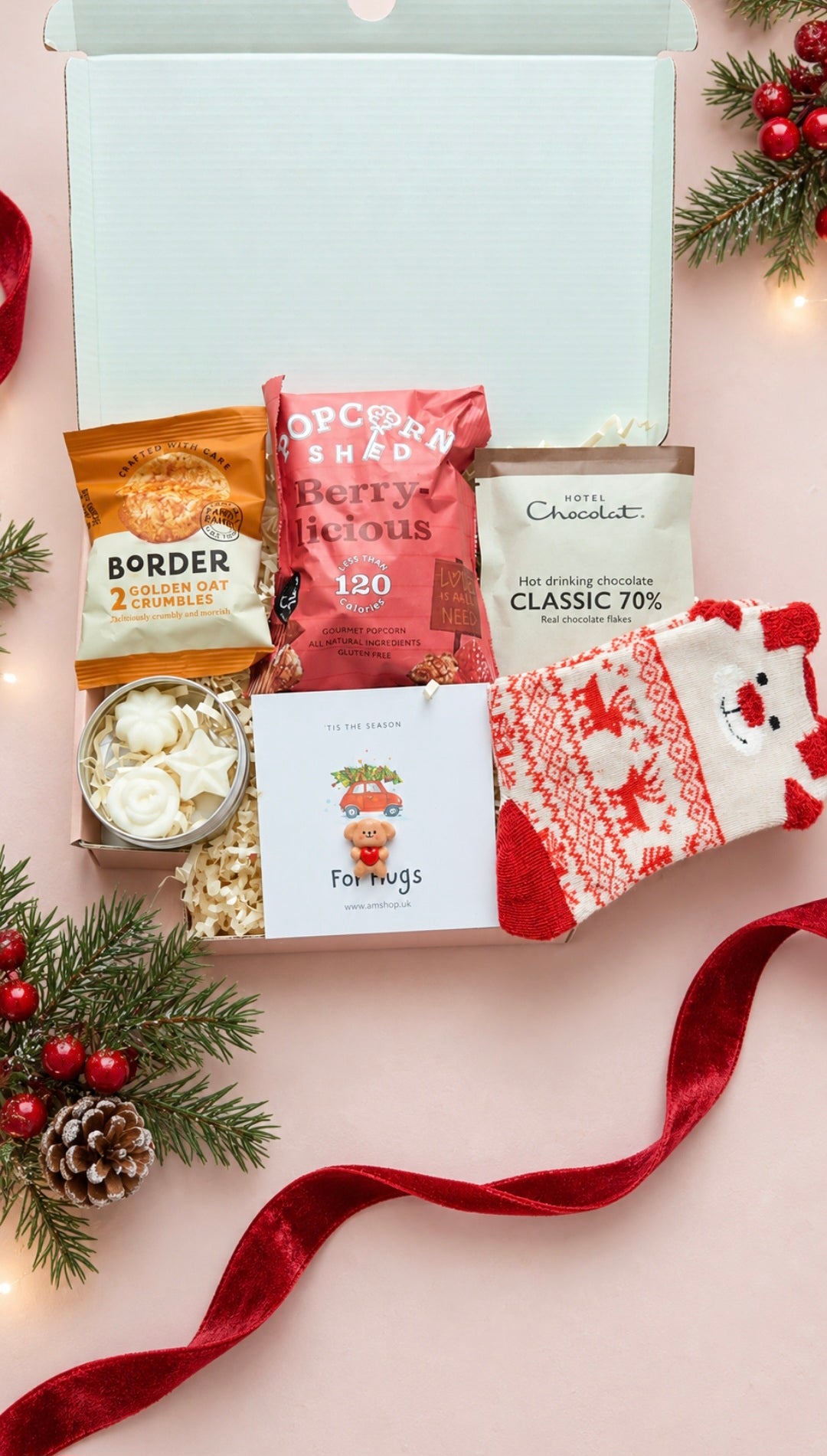 Cosy Festive Night In gift box with festive socks, Hotel Chocolat hot chocolate, popcorn, biscuits, wax melts and pocket hug.